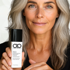 Woman holding a skincare product with a neutral background