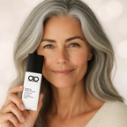 Woman holding a skincare product with a neutral background