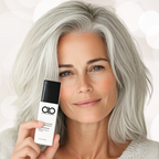 Woman with gray hair holding a skincare product with 'ab' branding.